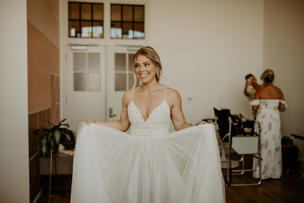5 WAYS TO LOOK LESS TIRED Bride holding wedding dress 